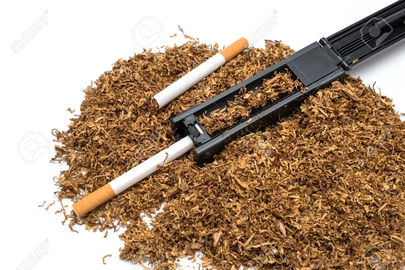 65869752 maquina de tabaco a la rodadura y tubo de vacio de cigarrillos y el tabaco en el fondo blanco