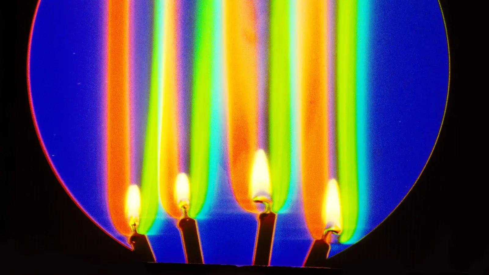Fotografia schlieren en color del aire caliente que sube sobre cuatro velas encendidas